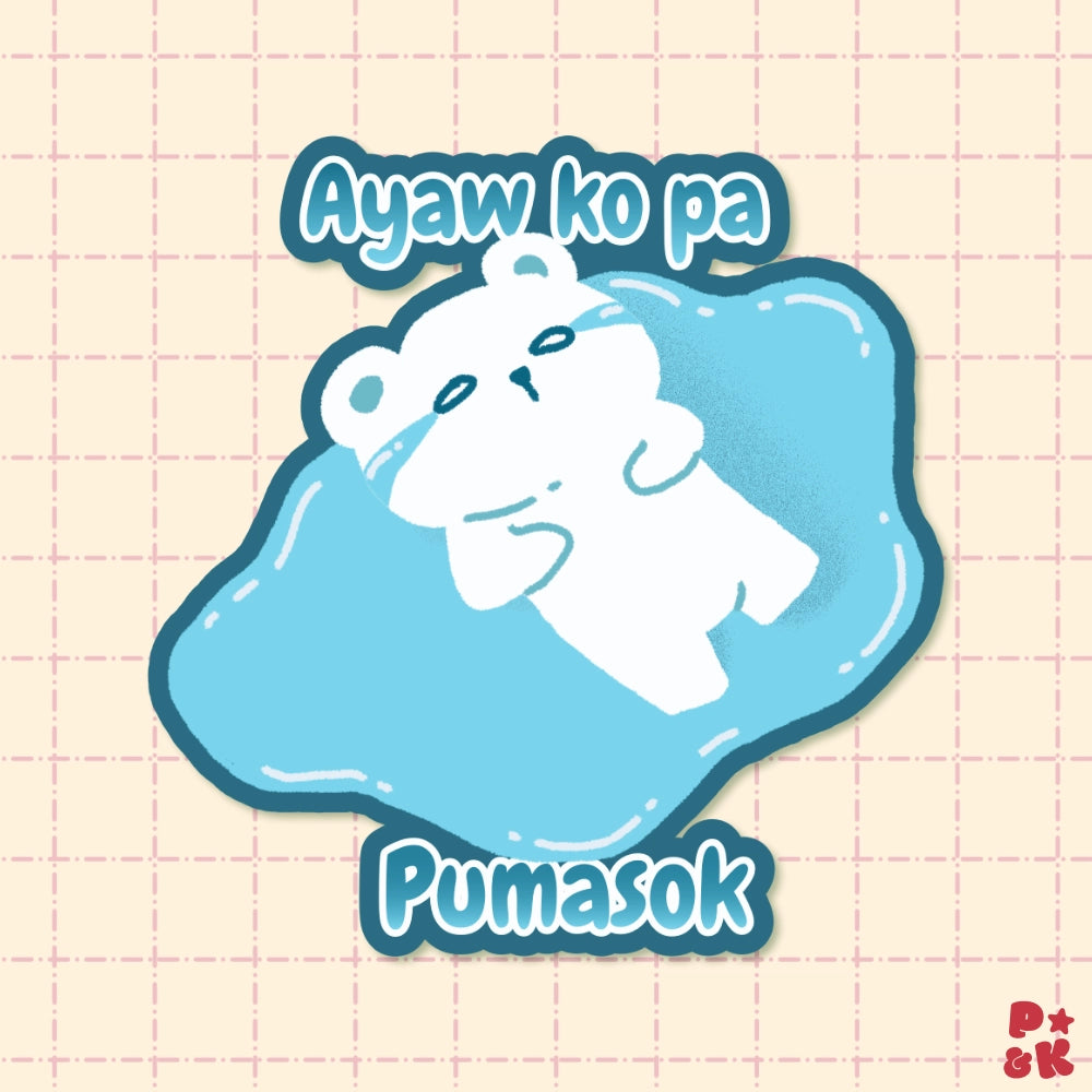 A cute cartoon sticker-style design showing a white bear lying on a light blue puddle of tears, with the text 'Ayaw ko pa Pumasok' above and below. The artwork is centered on a pale pink grid background.