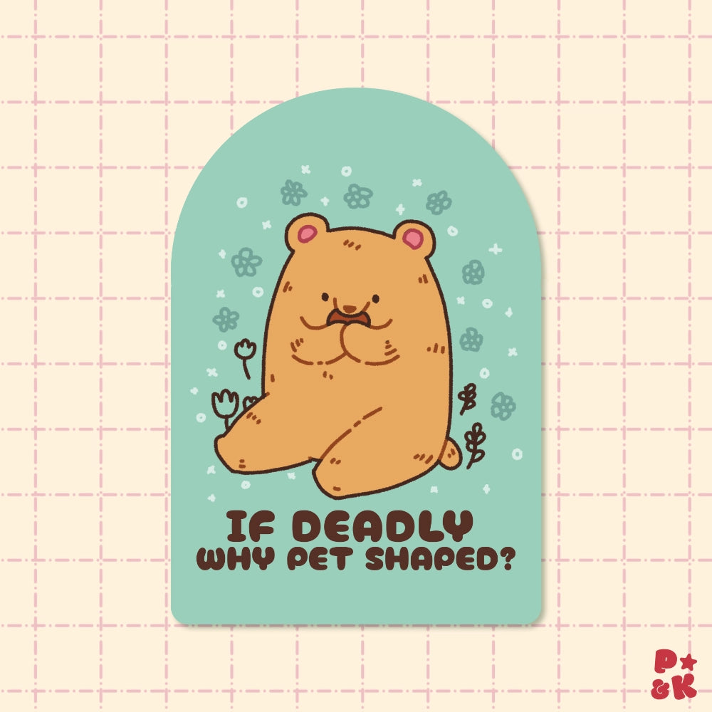 A die-cut sticker featuring a cute cartoon bearin a pet-shaped outline on a mint green background, with the text 'IF DEADLY WHY PET SHAPED?' below it. The sticker is displayed on a light pink grid-patterned background.